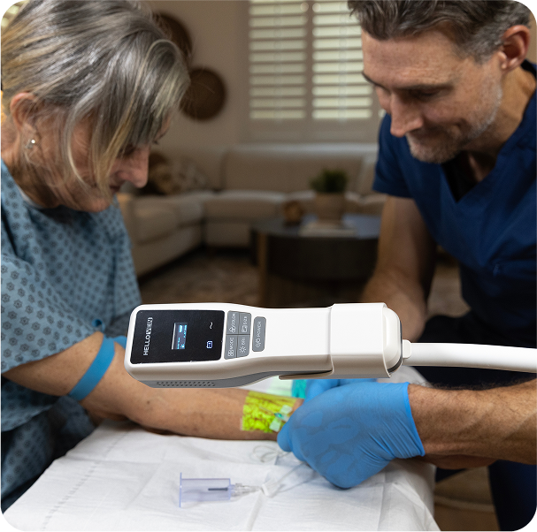 A physician wearing latex gloves is examining a patient’s hand using HelloVein.