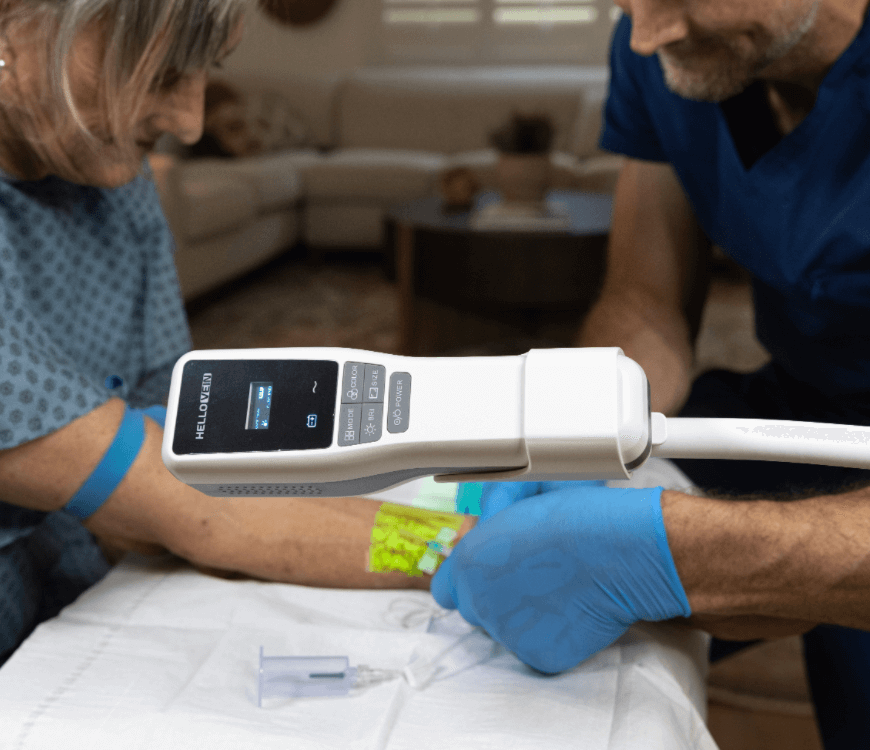 A clinician using the Hellovein Lite 2.0 with trolley to assist vein access on an elderly patient.