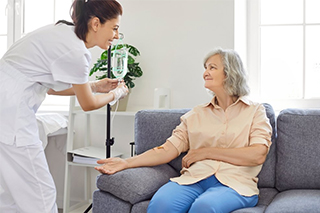 Eine Krankenschwester gibt einem älteren Patienten eine intravenöse Injektion in den Arm.